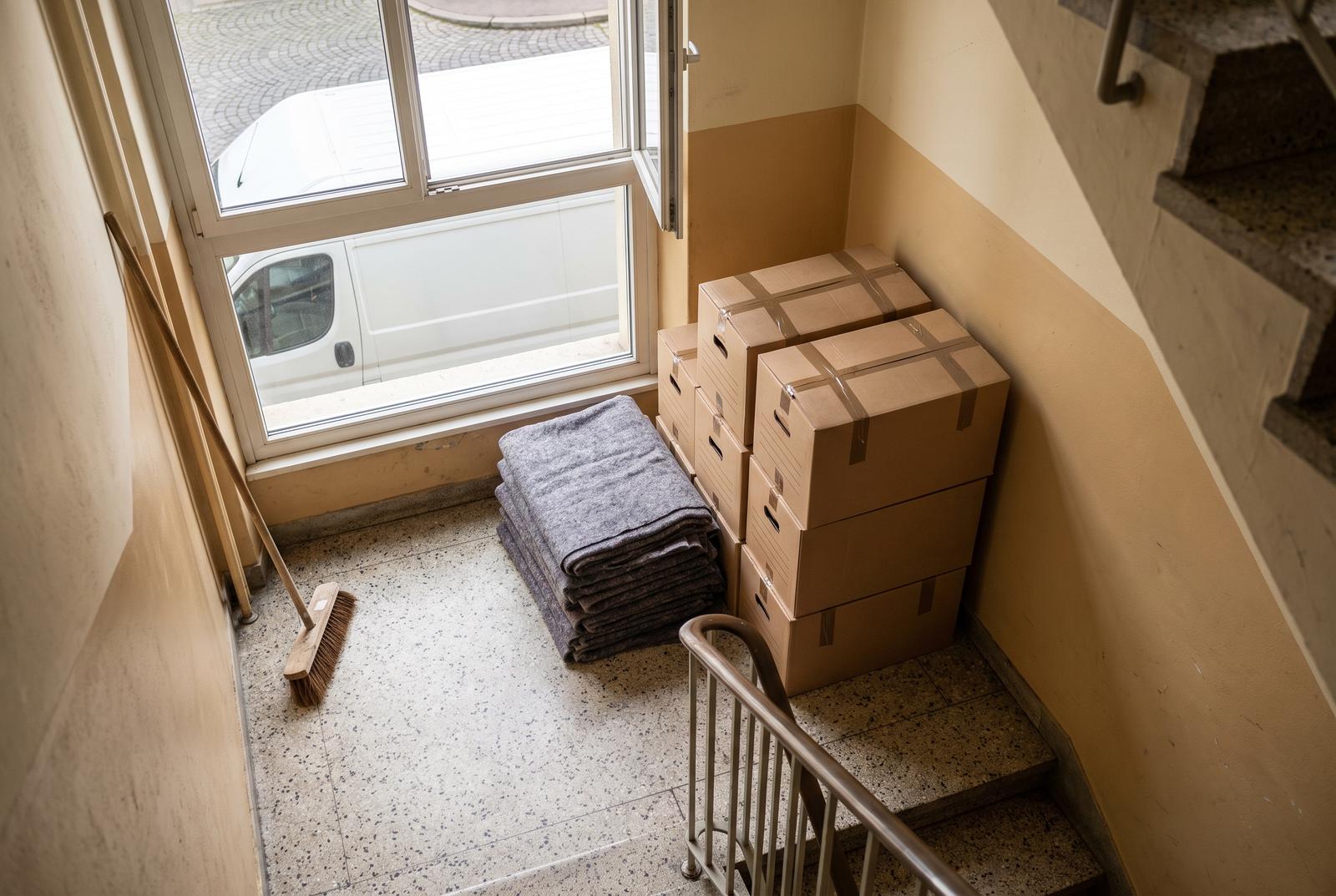 Räumung in Dietikon — Kartons, Umzugsdecken und Besen im Treppenhaus eines Mehrfamilienhauses